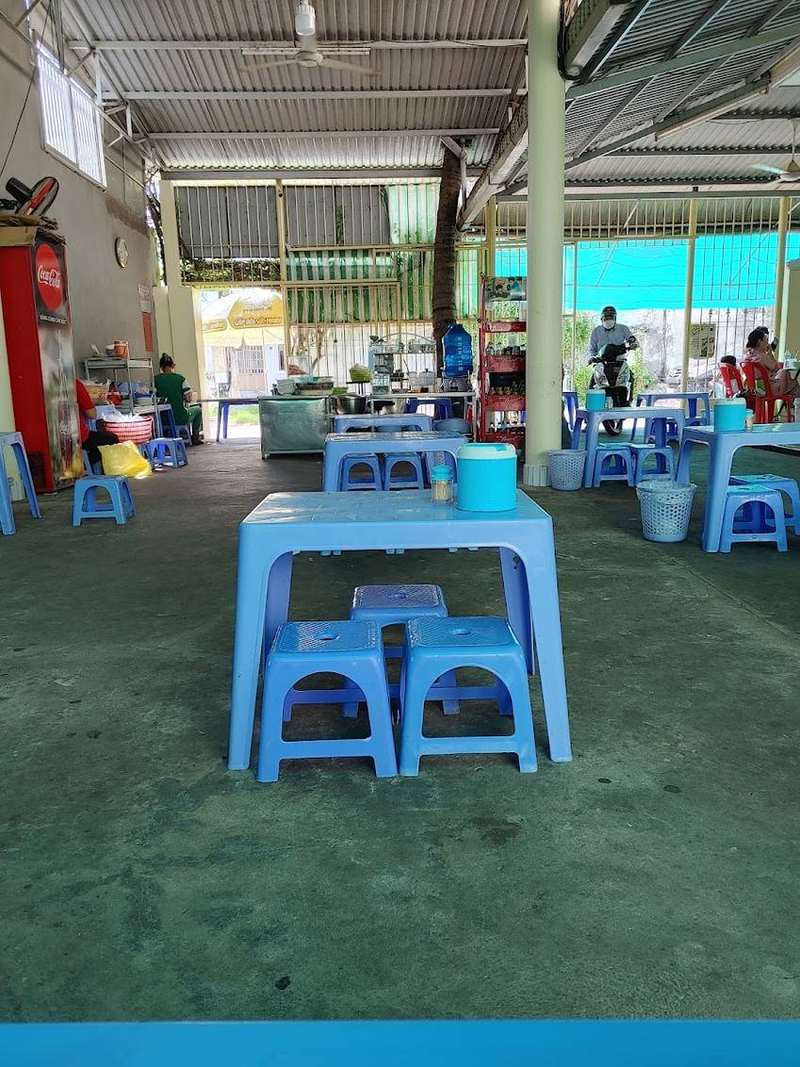 Dãy bàn ghế nhựa xanh thấp dưới mái tôn