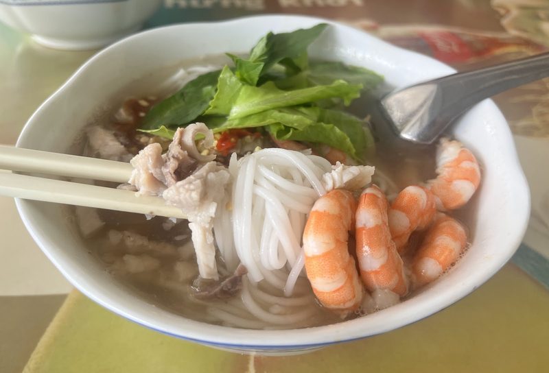 Gắp bún và thịt từ tô bún gỏi dà đầy tôm