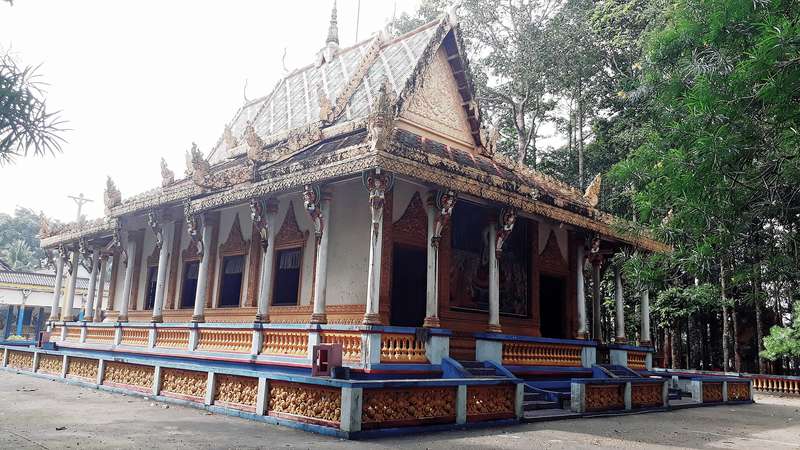Chánh điện chùa Dơi với mái nhiều tầng giữa hàng cây cao