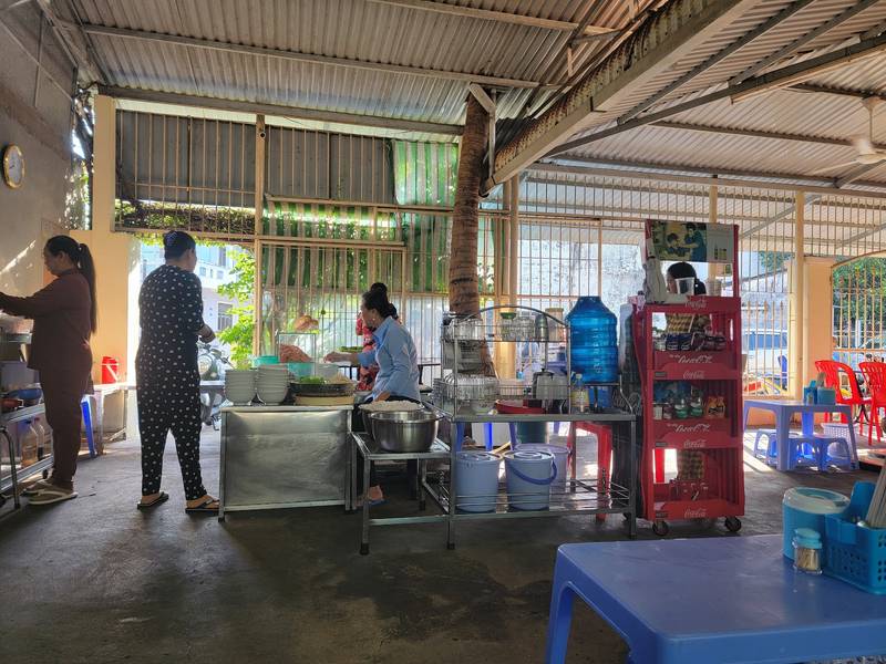Bên trong quán Bún Gỏi Dà Cô Hằng: mái tôn rộng và quầy nấu